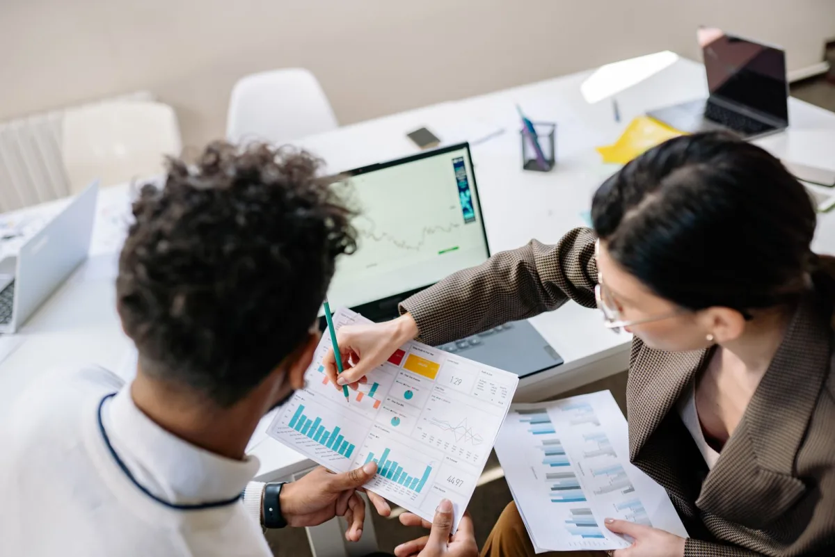 Colleagues analyzing financial graphs together in a meeting room