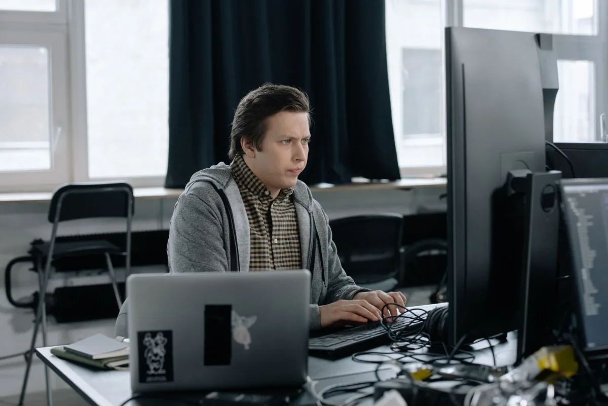 Software engineer coding on a dual-monitor workstation