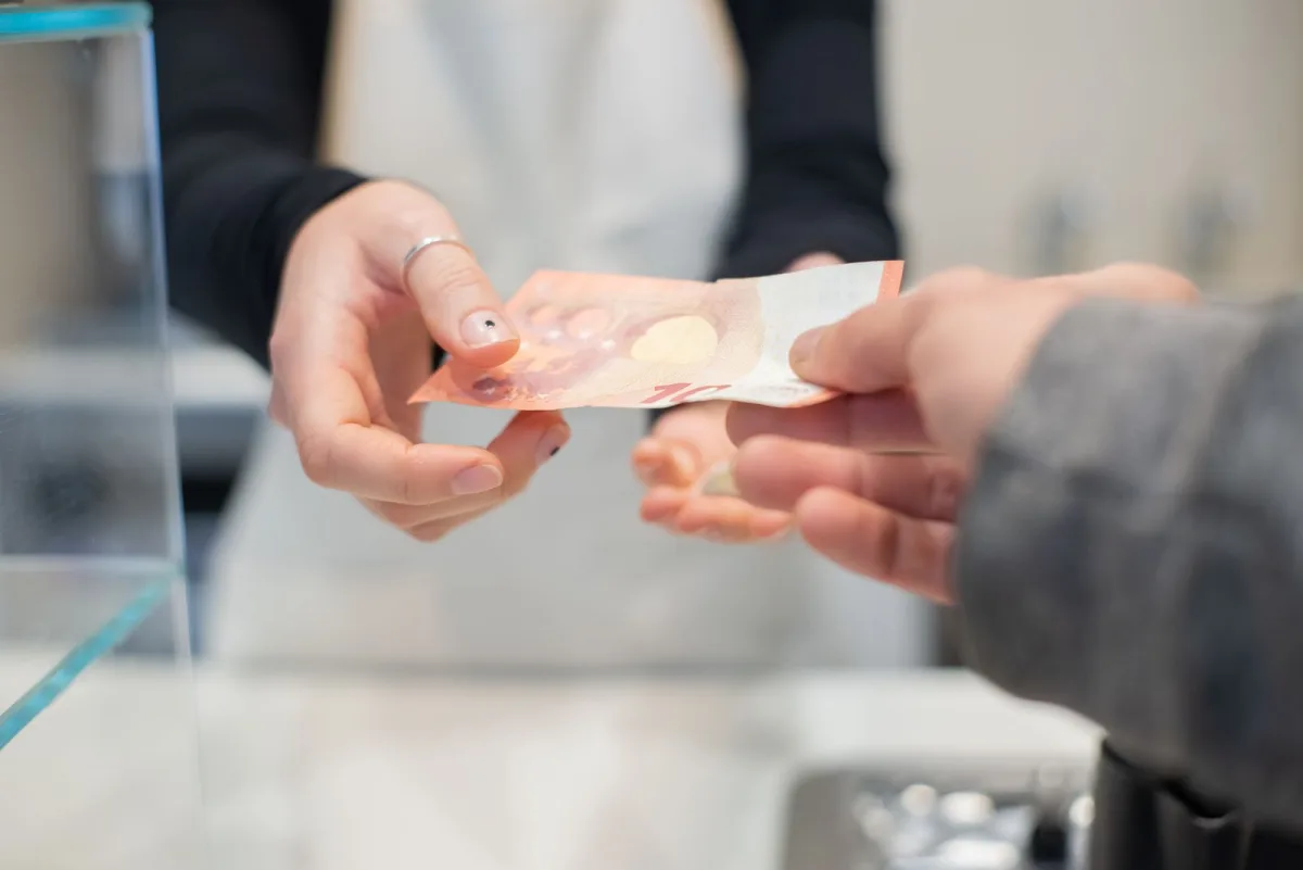Customer paying a bill with cash at a counter