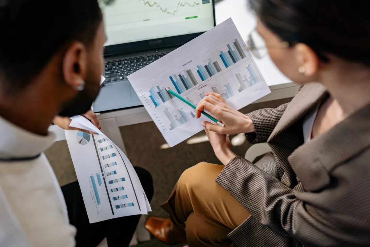 Two consultants discussing charts on printed reports