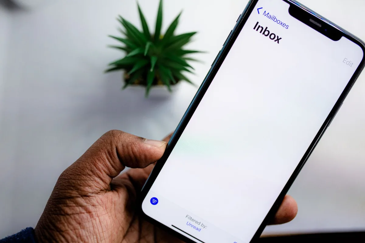 Hand holding a smartphone showing an empty email inbox