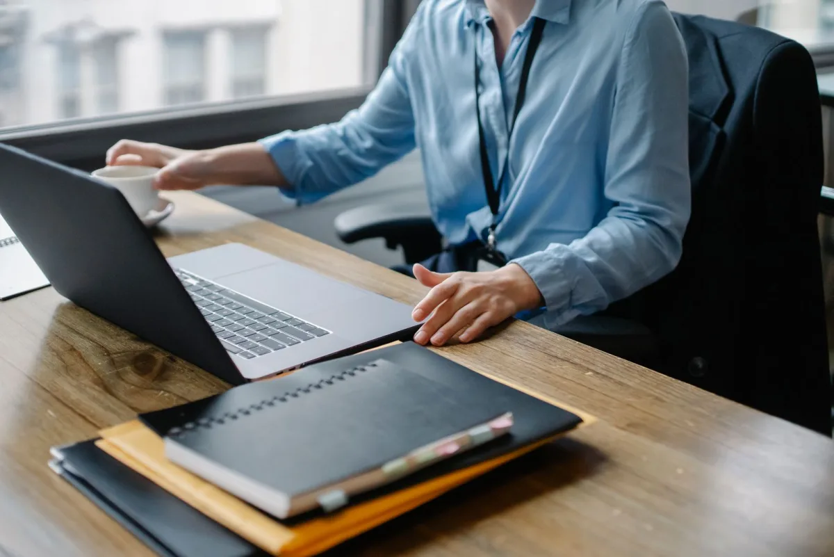 Woman writing on her laptop with a cup of coffee