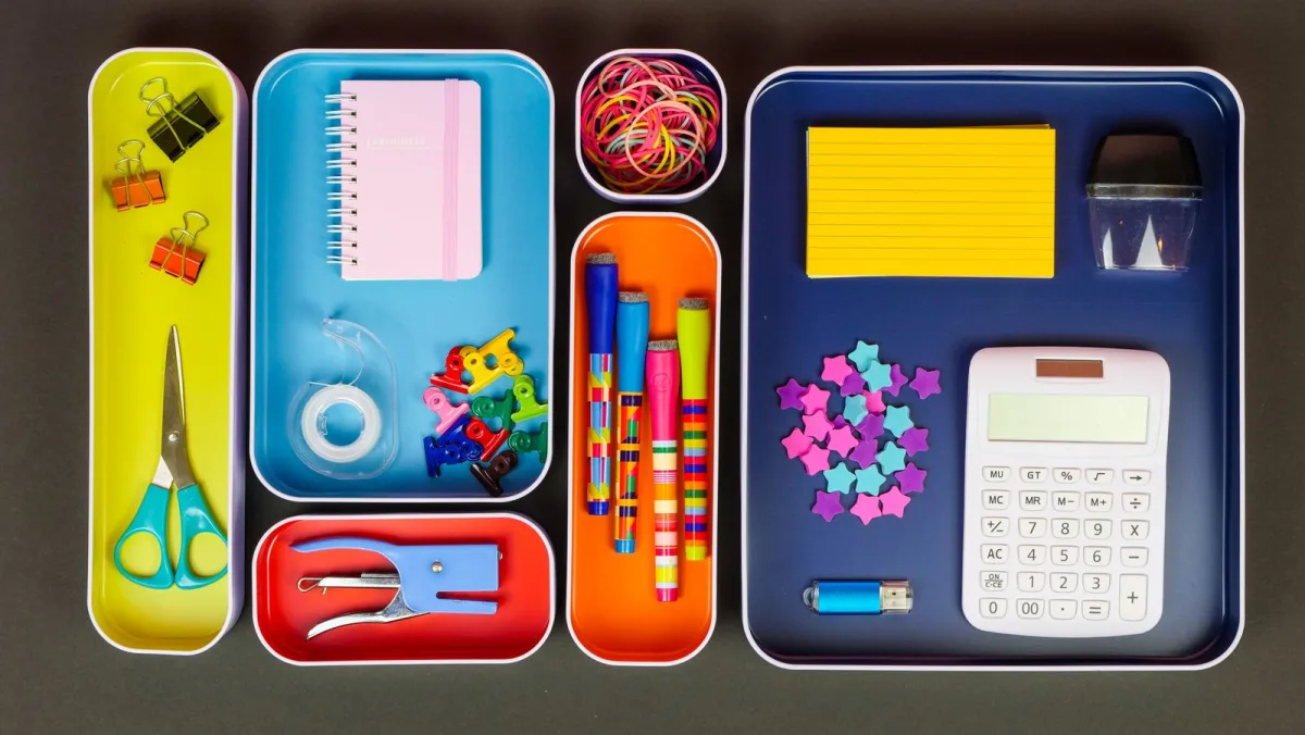 Neatly organized desk with laptop, notebooks and office supplies