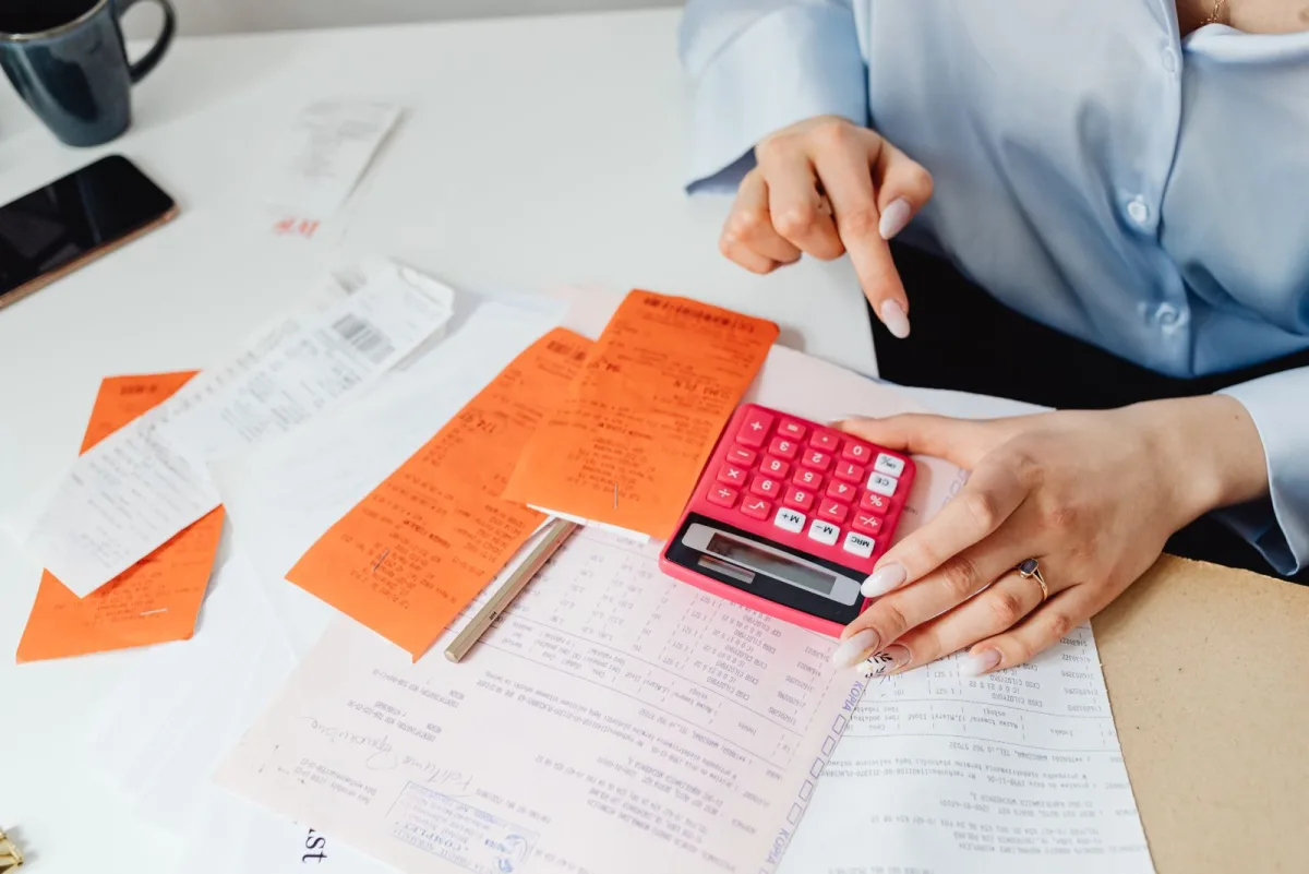 Woman calculating receipts and invoices with a calculator
