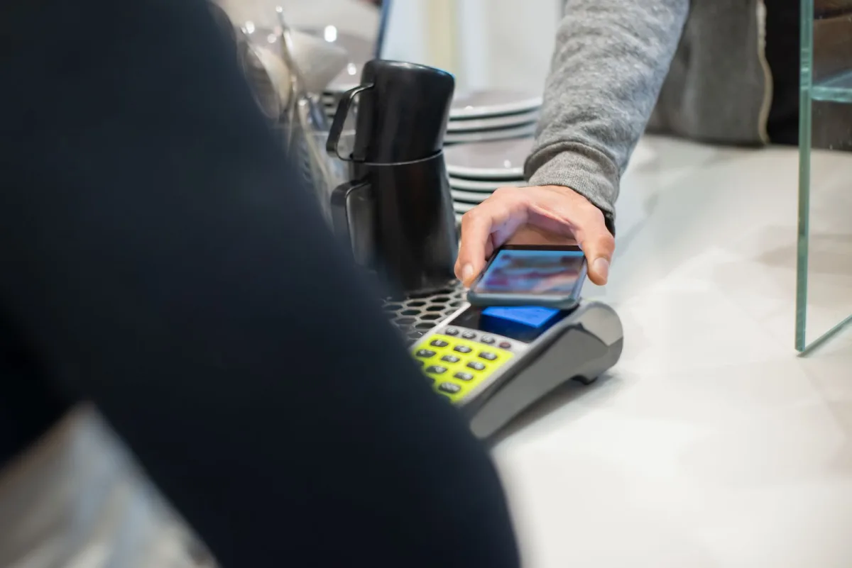Customer making a cashless card payment in a coffee shop