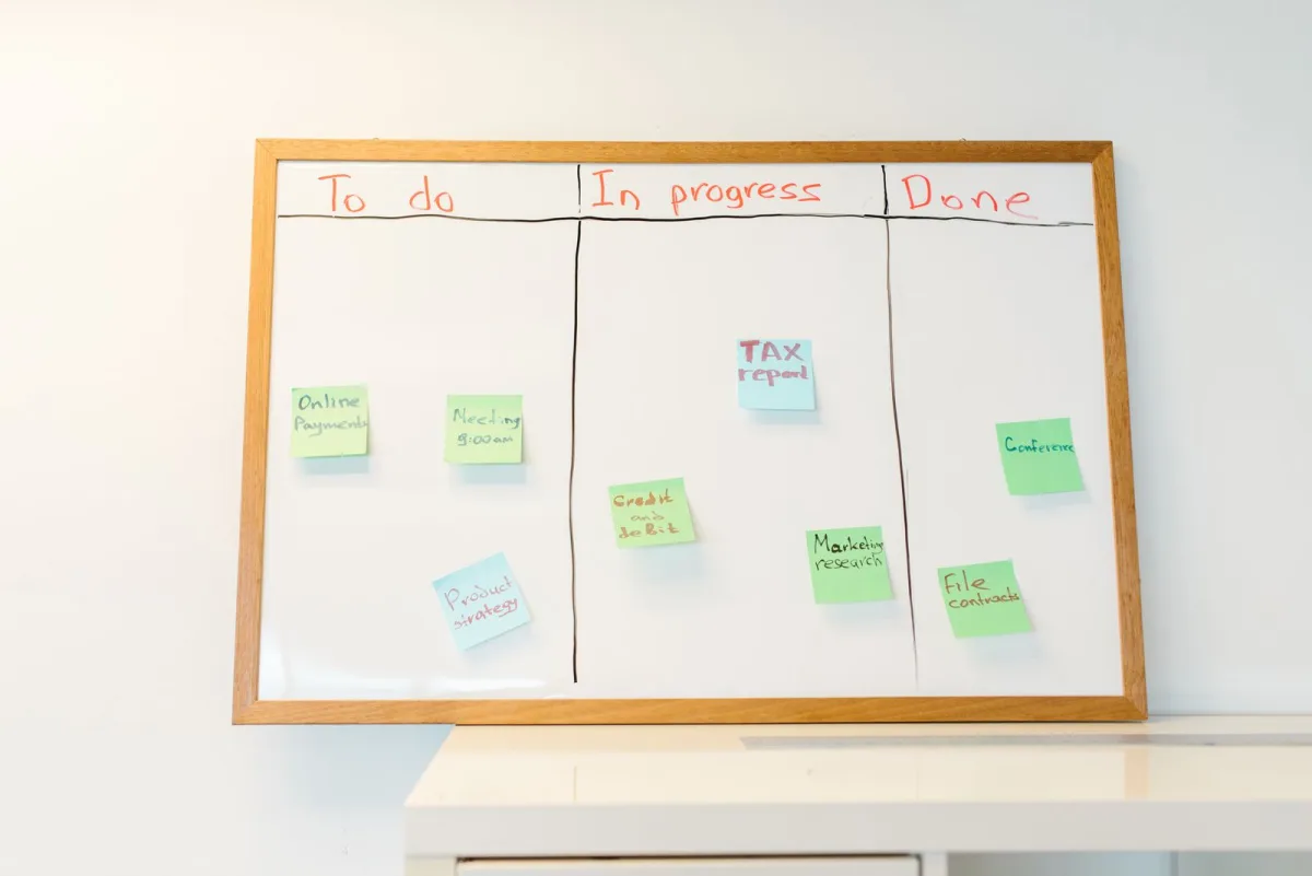 Kanban board with colorful sticky notes on a whiteboard