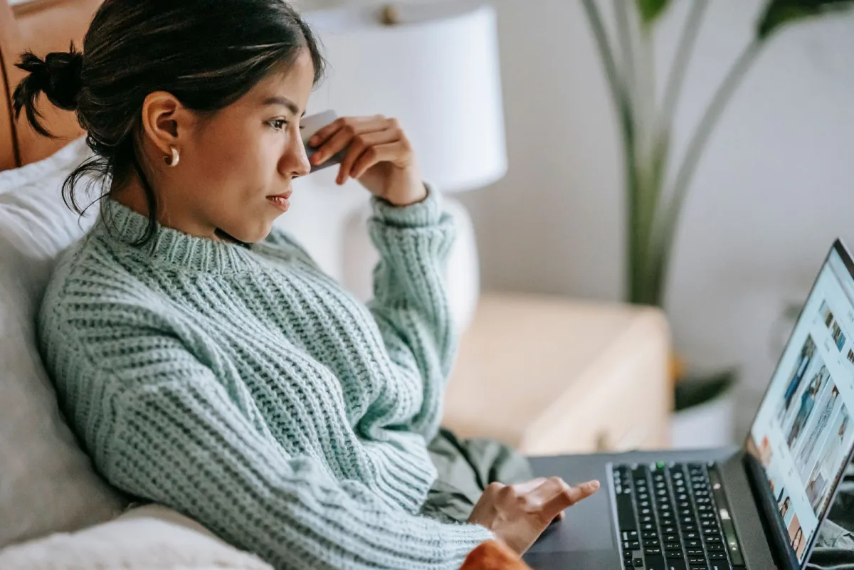 Woman shopping online with a credit card and laptop