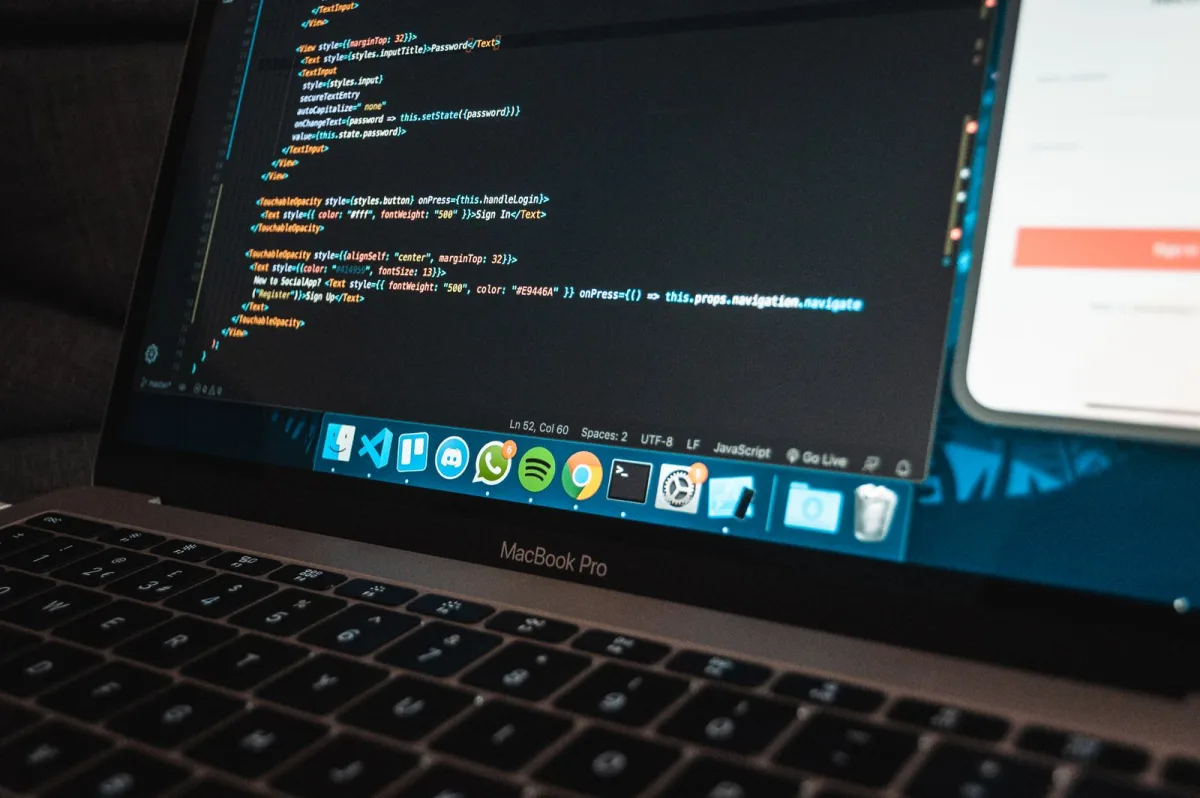 Laptop mit Programmcode auf einem Schreibtisch-Arbeitsplatz