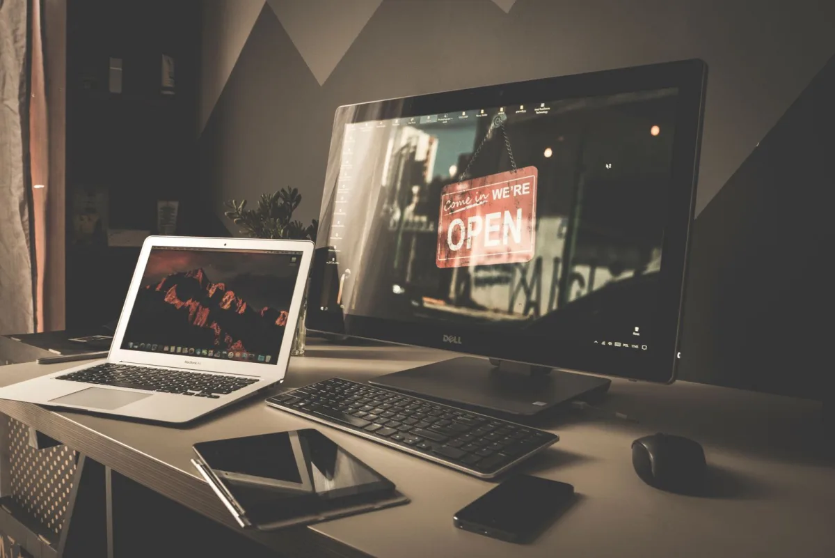 Arbeitsplatz-Setup mit Laptop, Monitor und Zubehör auf dem Schreibtisch