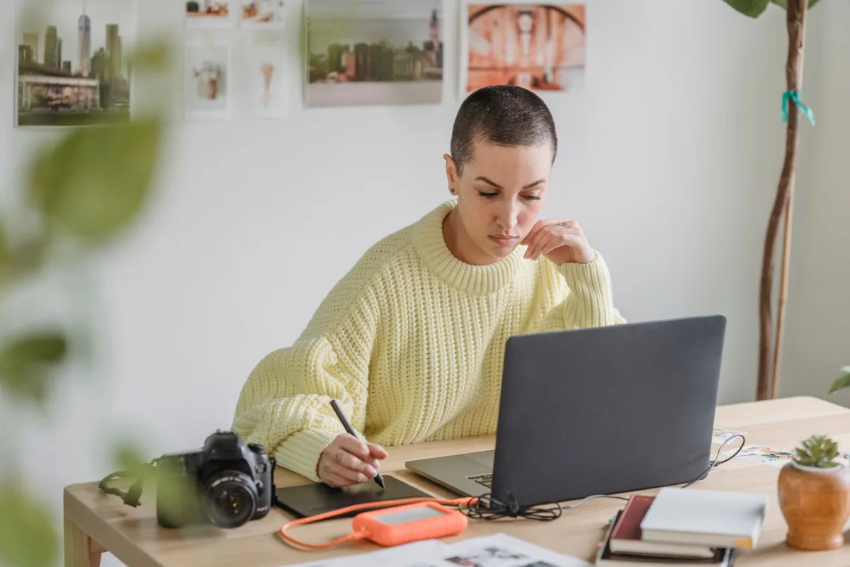 Designer drawing on a graphics tablet while working on a laptop