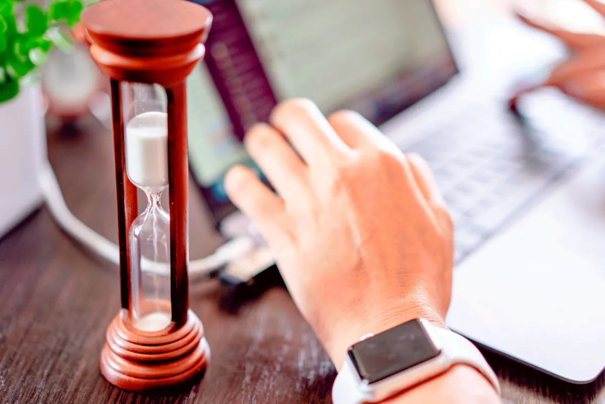 Hourglass standing on a wooden desk