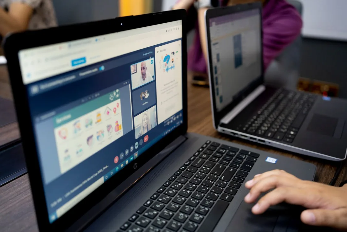 Laptop showing a video call with colleagues in several locations