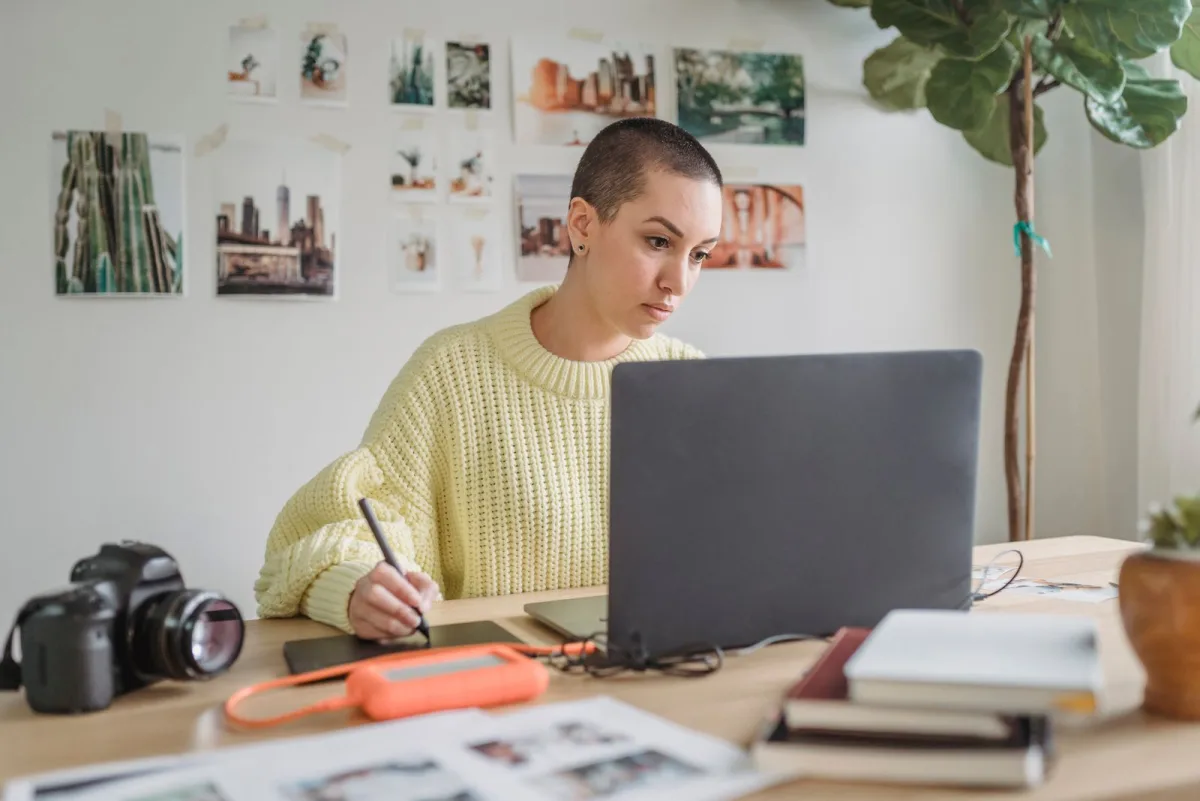 Designer working on a laptop with a drawing tablet