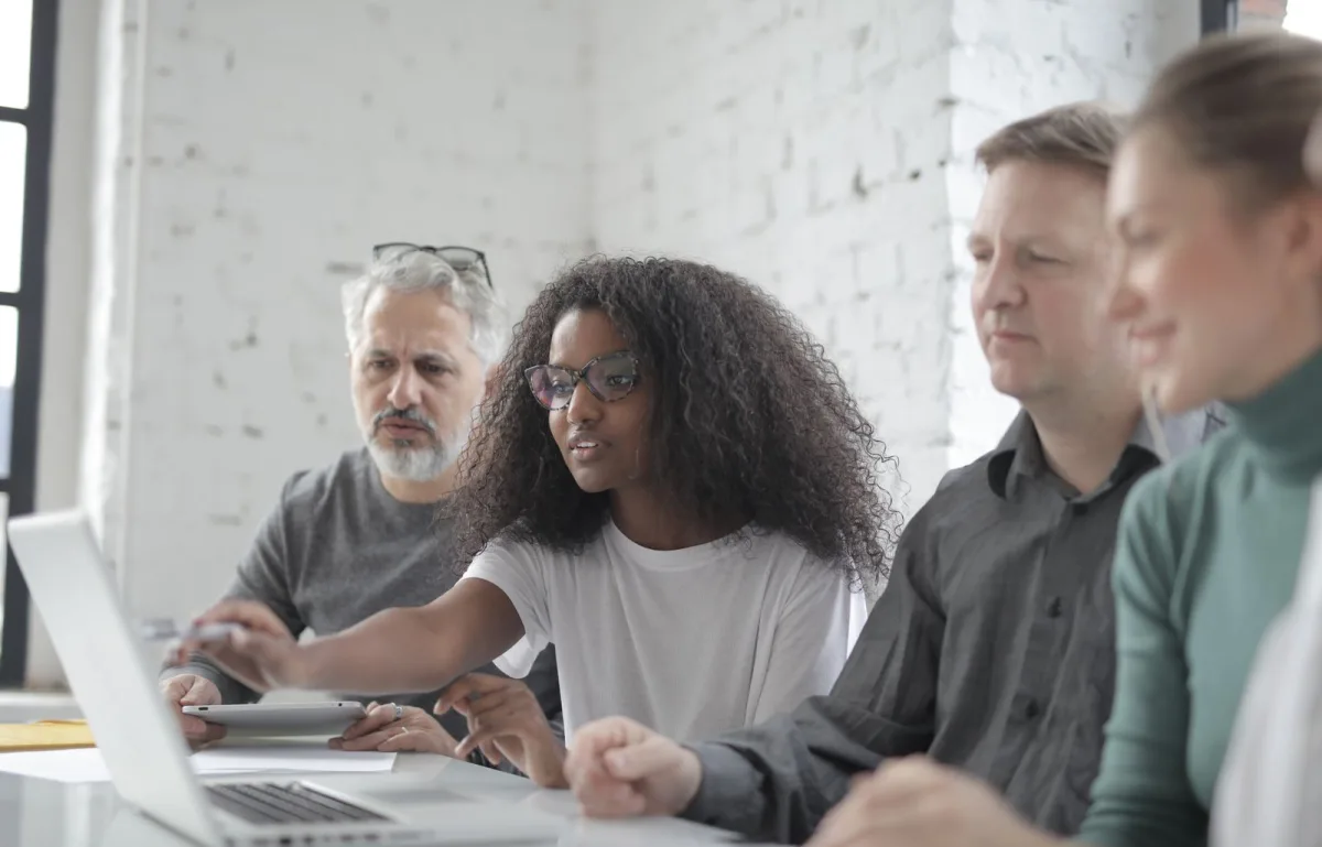 Team of colleagues reviewing work together on a laptop