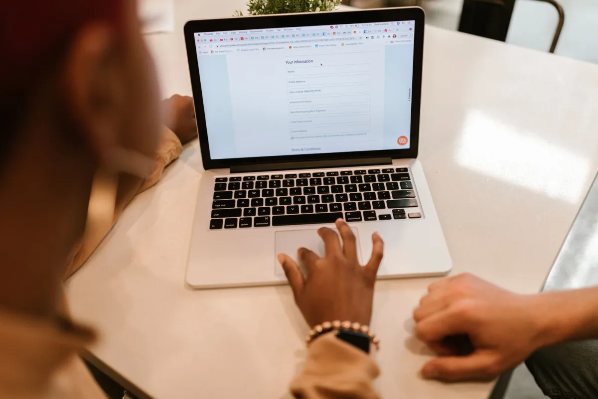 Person füllt am Laptop ein digitales Formular aus