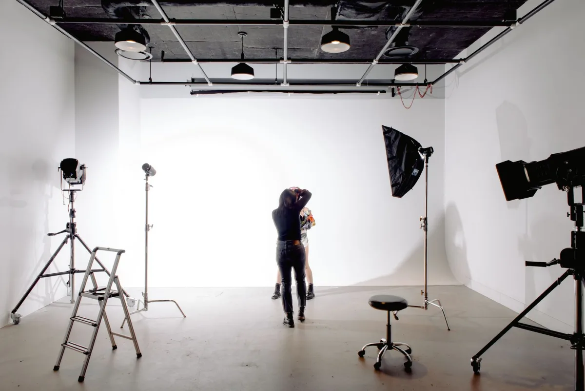 Fotograf bei einem Shooting im Studio mit Kamera und Lichtaufbau