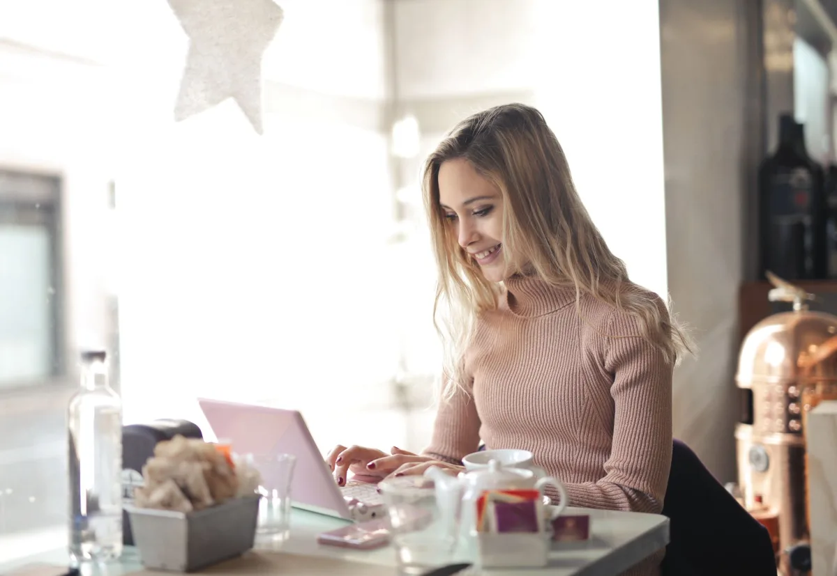 Frau im braunen Pullover bei der Arbeit am Laptop