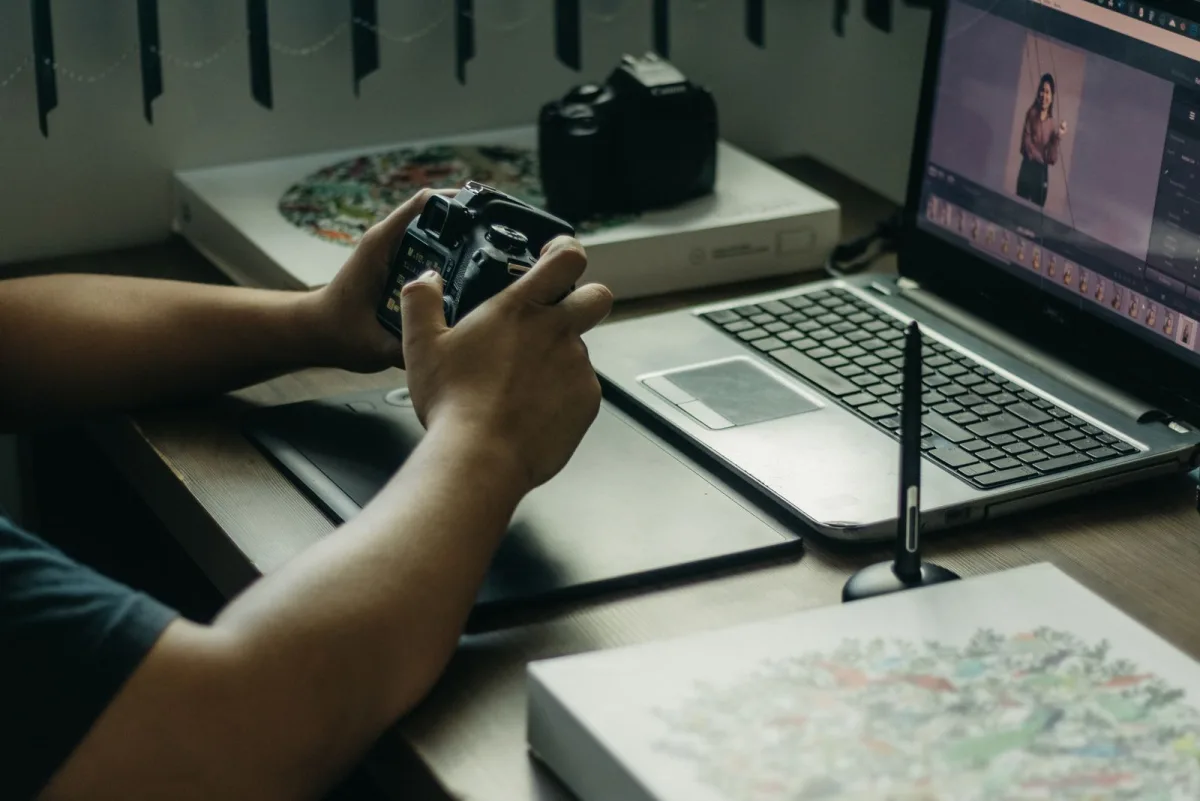 Photographer editing photos at a desk with laptop and stylus