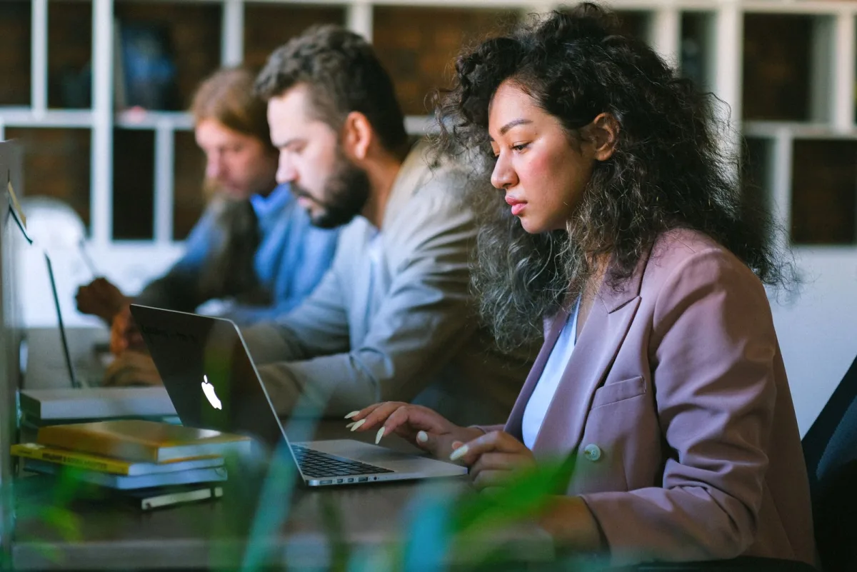 Two freelancers working side by side on laptops