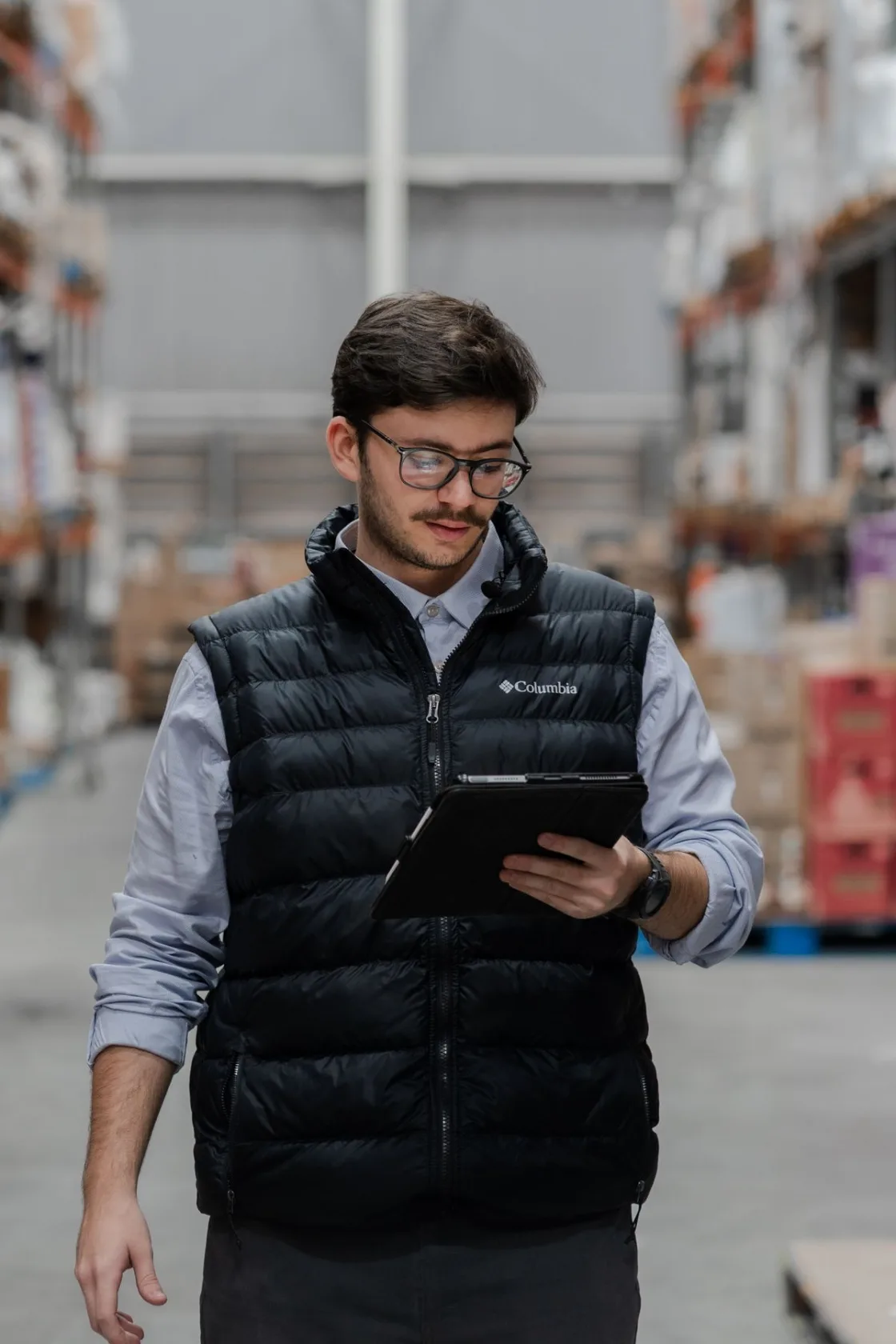 Seller at a desk with parcels, a tablet and a monitor