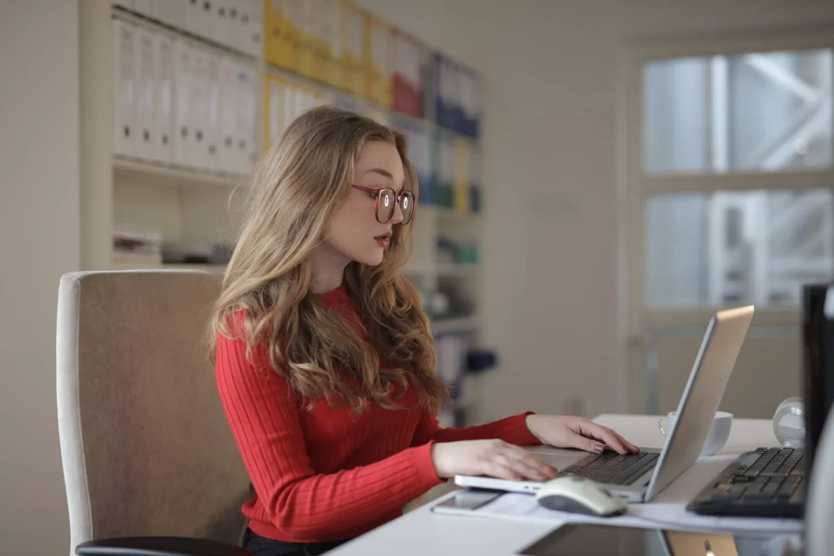 Konzentrierte Selbstständige arbeitet am Laptop und behält ihre Zahlen im Blick