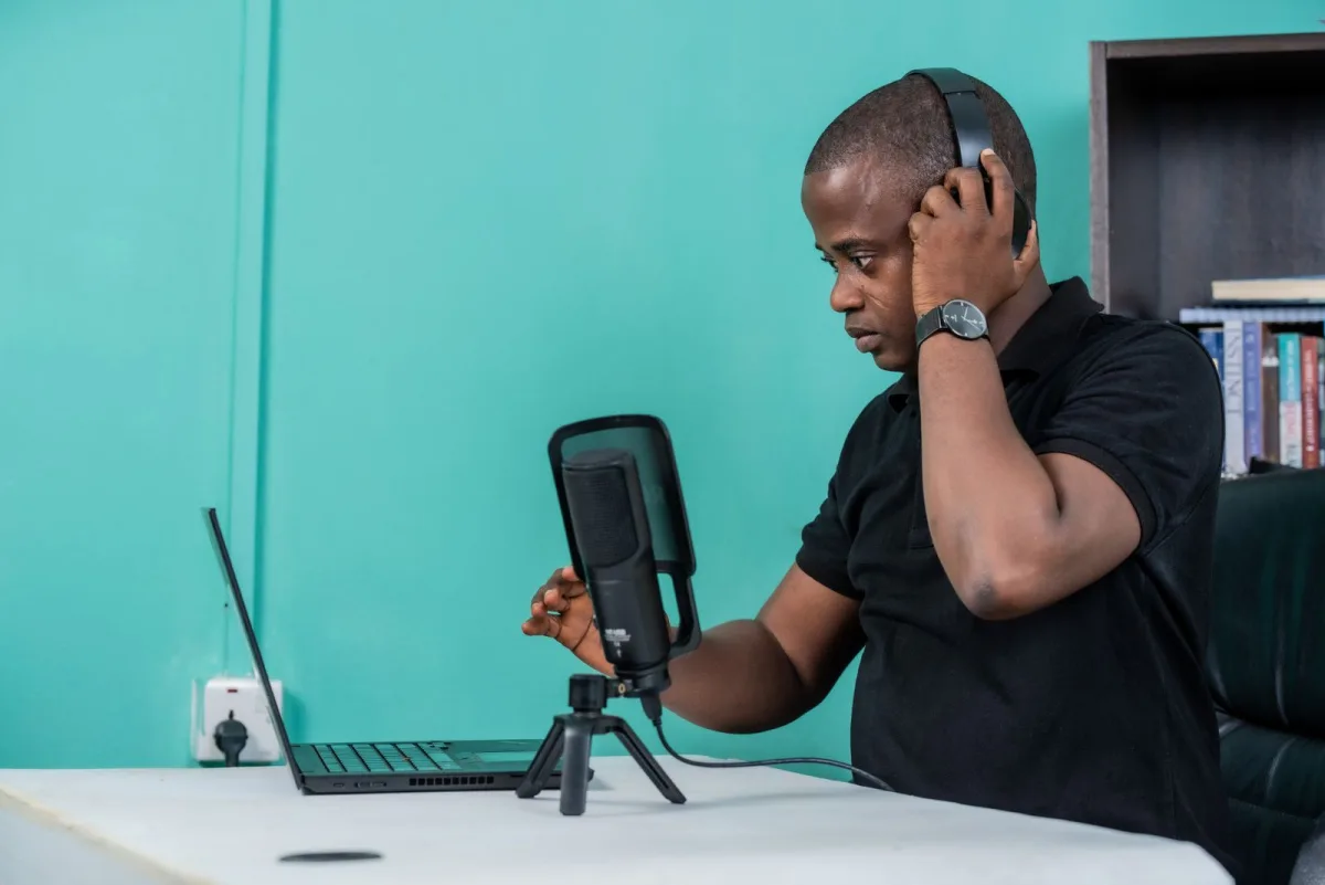 Creator recording a podcast with a laptop and microphone