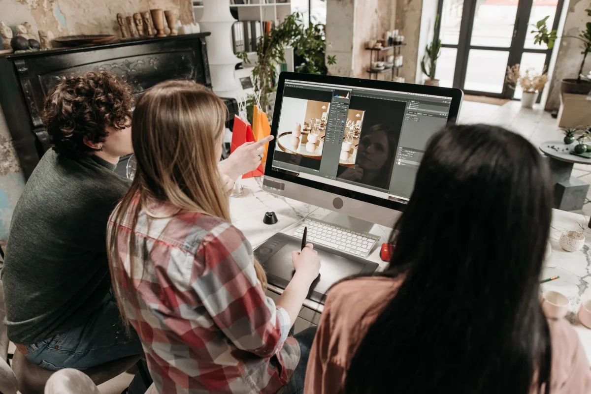 Team members working together in front of a desktop computer