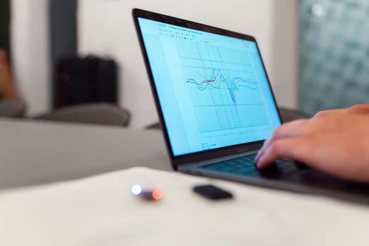 Person analyzing graphs on a laptop screen