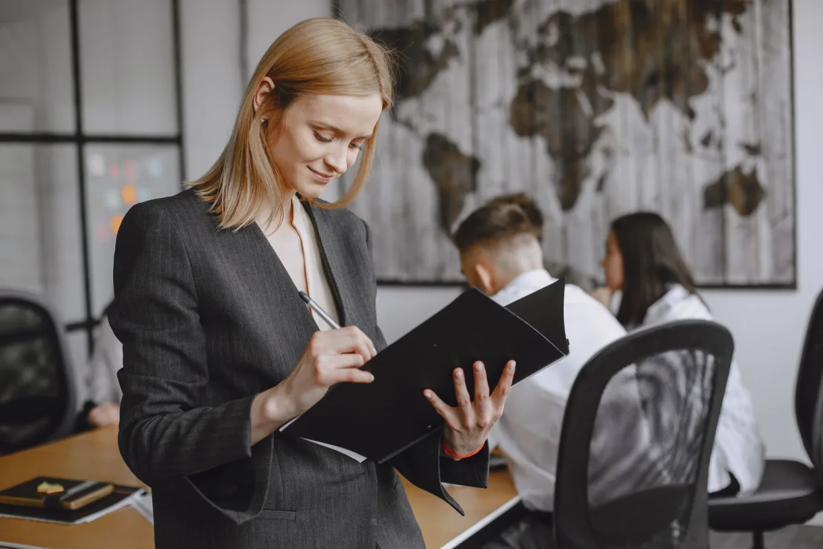 Woman taking notes at a desk in an office