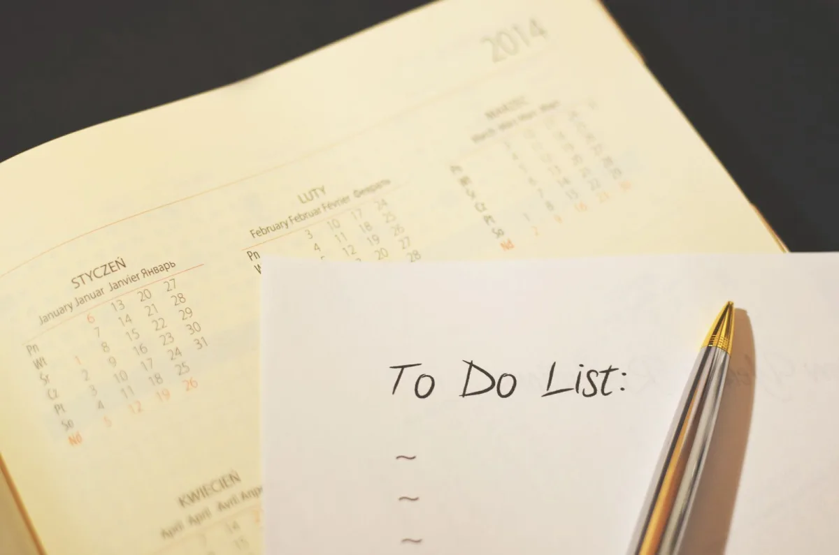 Pen lying on a paper calendar and to-do checklist